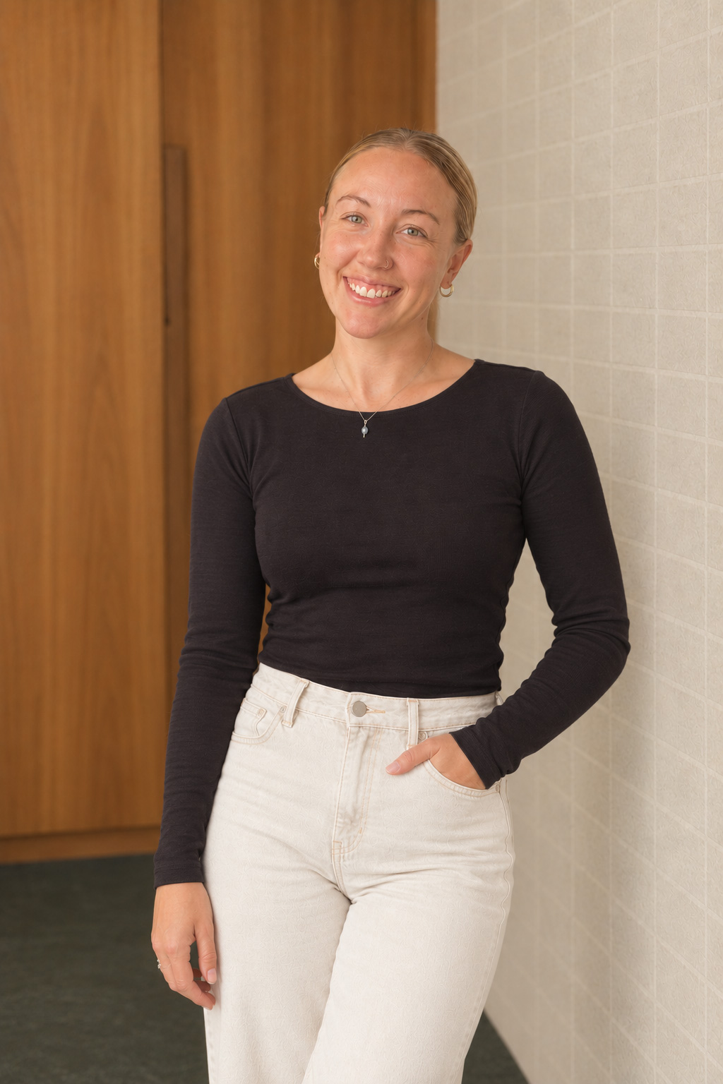 Madison Hardy standing next to the wall in an architectural interior